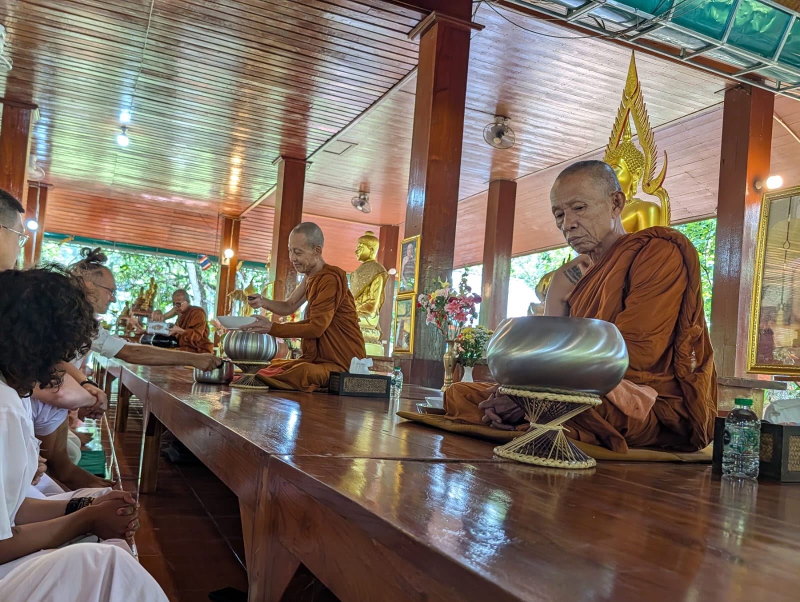 Laypeople in white offering food to monks
